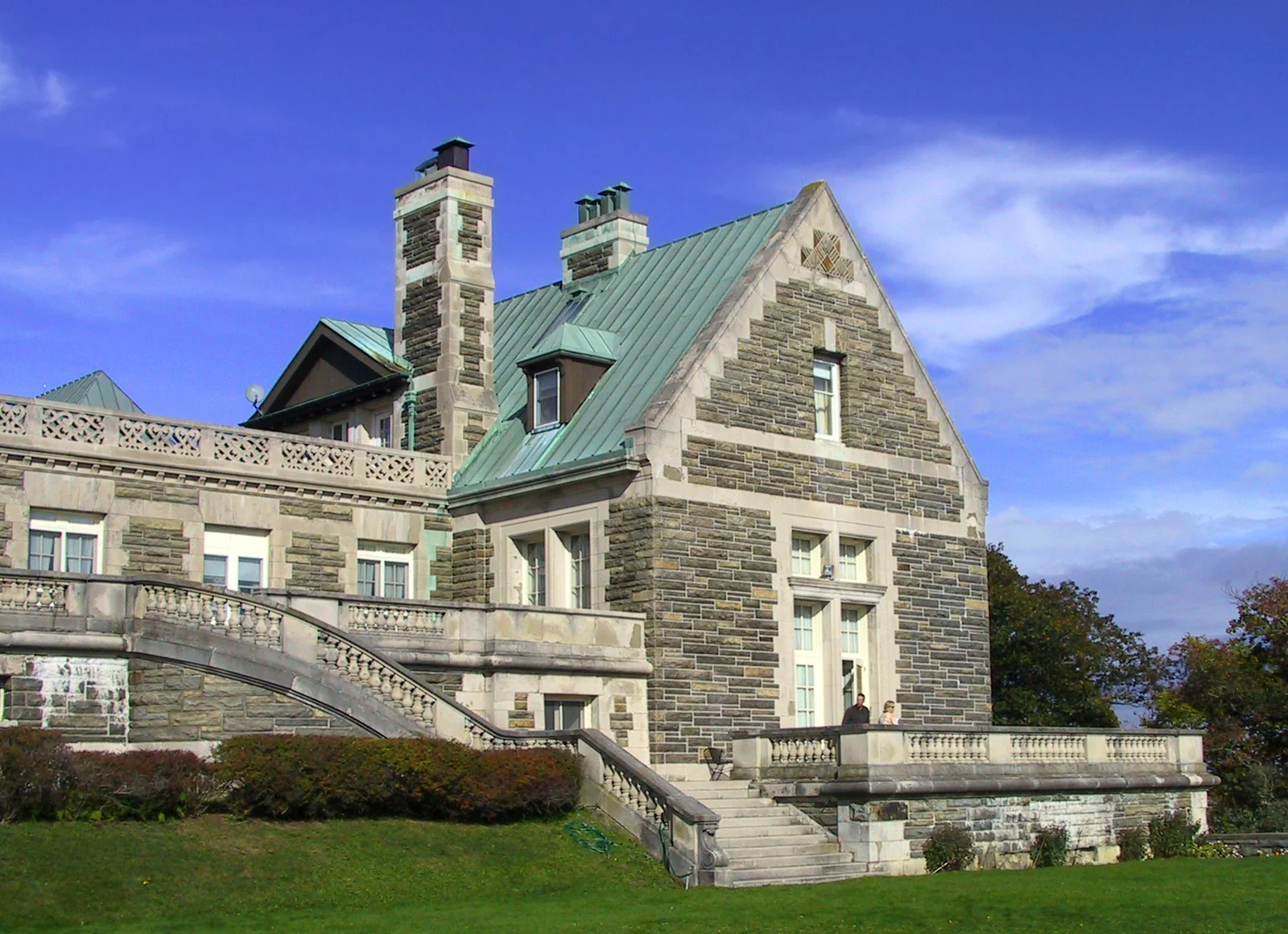 Grande villa in pietra in stile neorinascimentale immersa nel verde collinare, con facciata simmetrica e alti camini: la Arden House sulla tenuta Harriman, nello stato di New York.