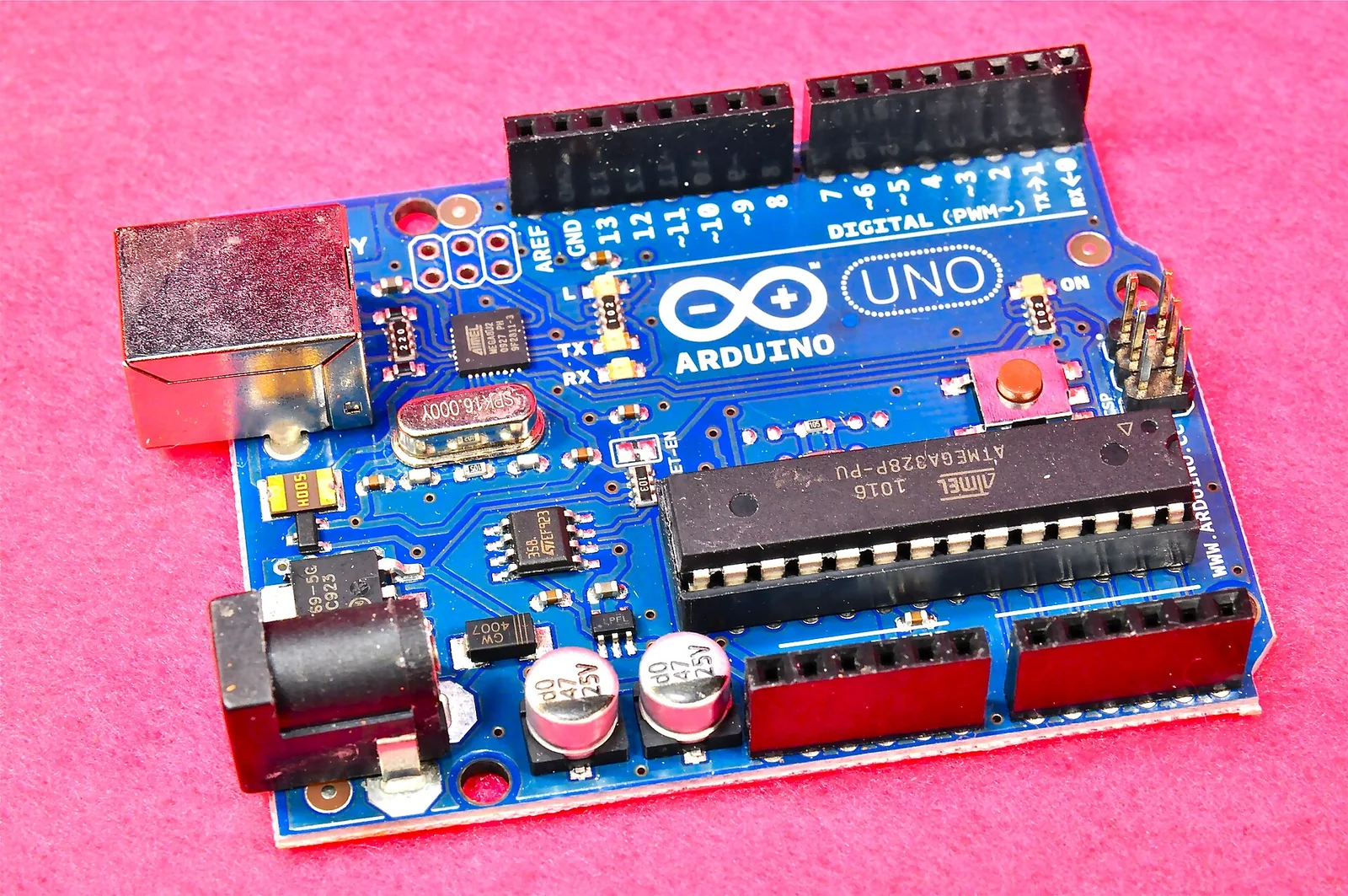 Una scheda elettronica Arduino Uno con microcontrollore ATmega, connettore USB, jack di alimentazione e file di pin header lungo i bordi.