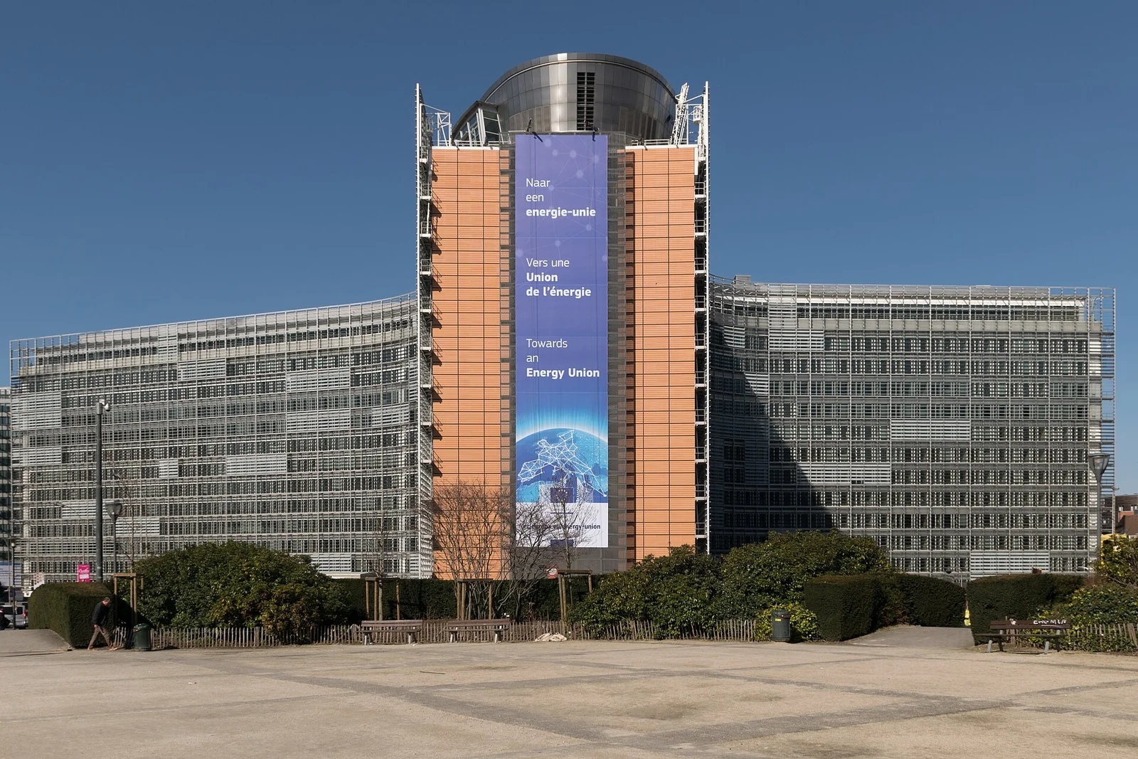 Il palazzo Berlaymont a Bruxelles, sede della Commissione europea, con la sua facciata curva in vetro e acciaio sotto un cielo limpido.