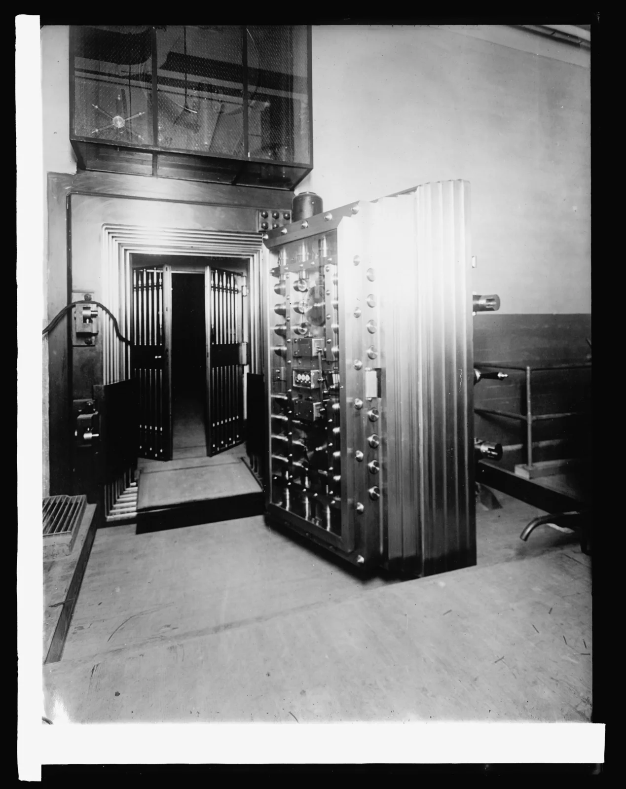 Fotografia in bianco e nero del 1914: la porta d'acciaio di un caveau, spalancata, con la fitta bulloneria sulla faccia interna; oltre la soglia un cancello a sbarre e l'interno del caveau.