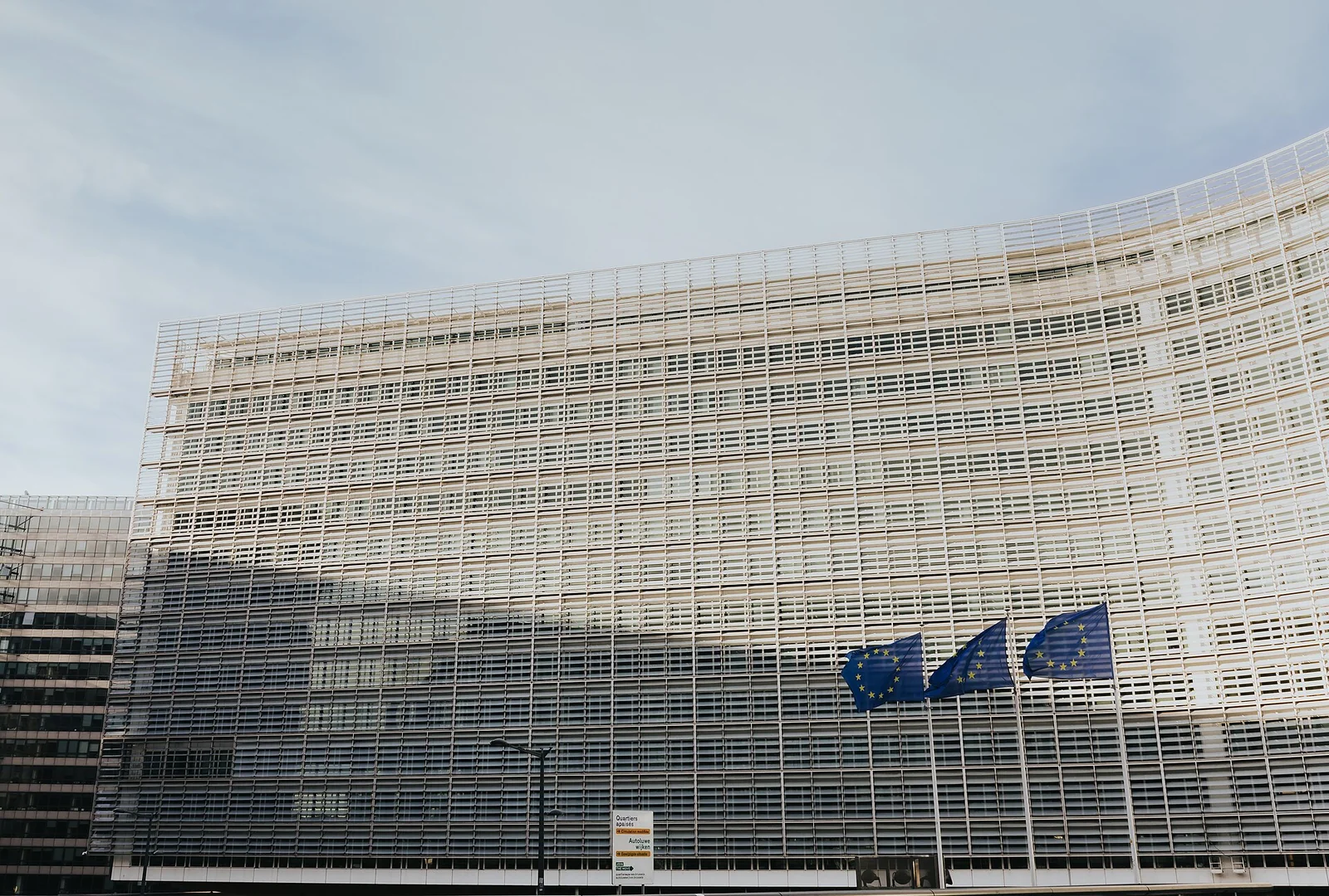 L'edificio Berlaymont a Bruxelles, sede della Commissione europea, con la bandiera dell'Unione Europea sulla facciata vetrata.
