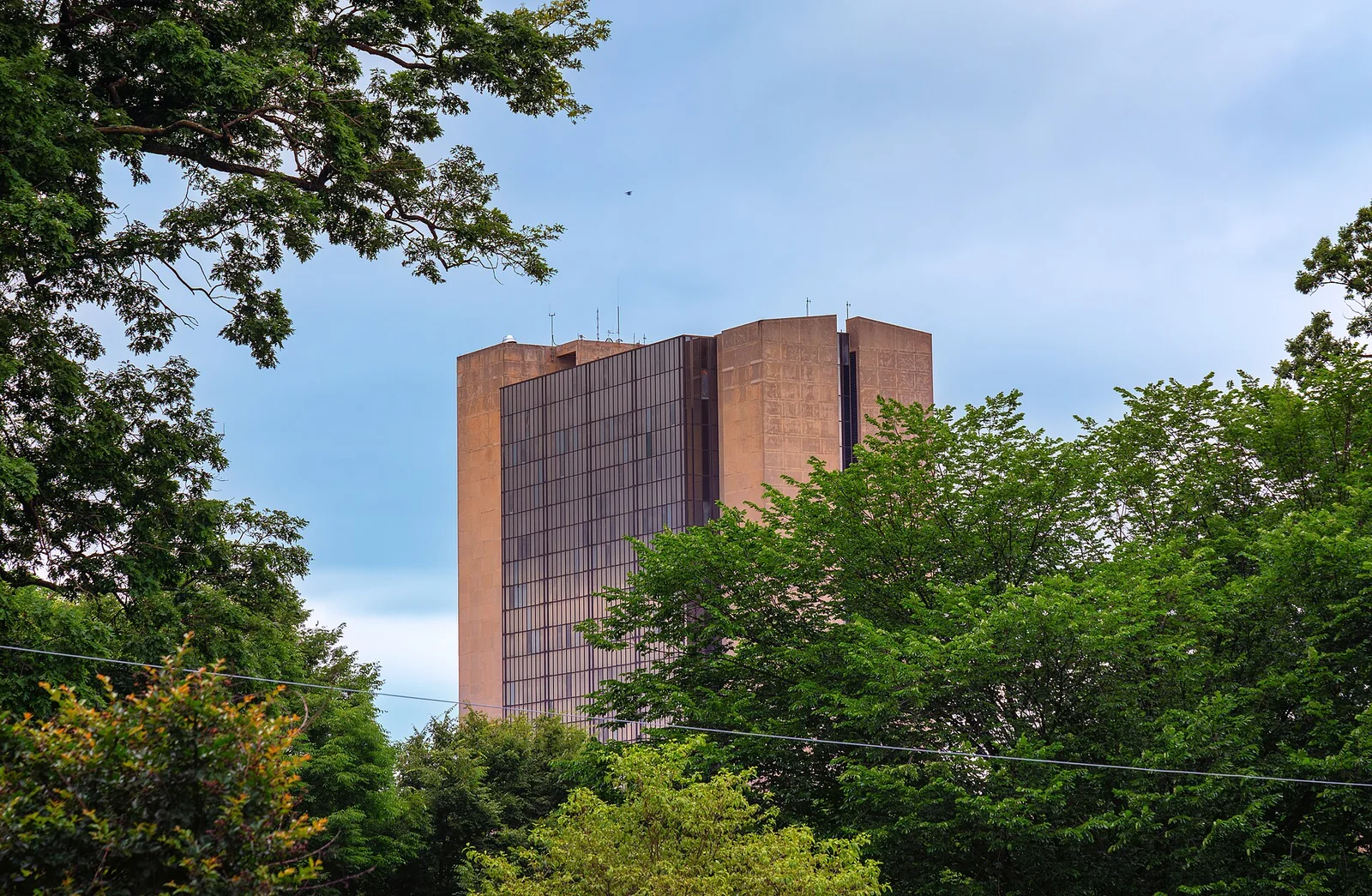 Edificio moderno in mattoni e vetro su più piani con scalinata d'ingresso, sede della National Library of Medicine nel campus NIH di Bethesda.