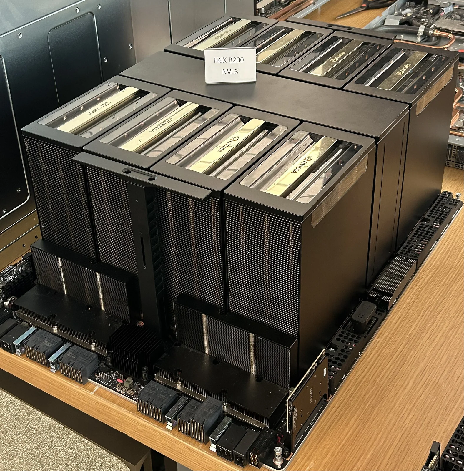 Baseboard NVIDIA HGX B200 a otto GPU: grande scheda quadrata con otto moduli GPU Blackwell montati e densi dissipatori e connettori di interconnessione NVLink.