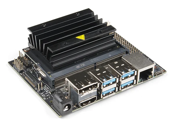 Scheda di sviluppo NVIDIA Jetson Nano vista dall'alto: PCB con dissipatore nero ad alette al centro, header GPIO a 40 pin, porte USB, Ethernet, HDMI e jack di alimentazione lungo i bordi.