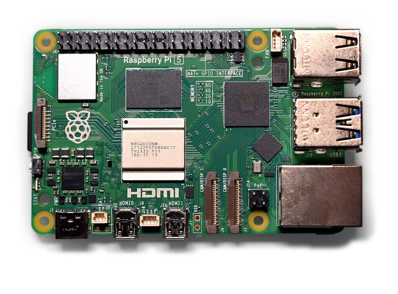Scheda Raspberry Pi 5 vista dall'alto: circuito stampato verde con il SoC quadrato, slot per due connettori a nastro, porte USB e Ethernet e i connettori GPIO lungo il bordo.
