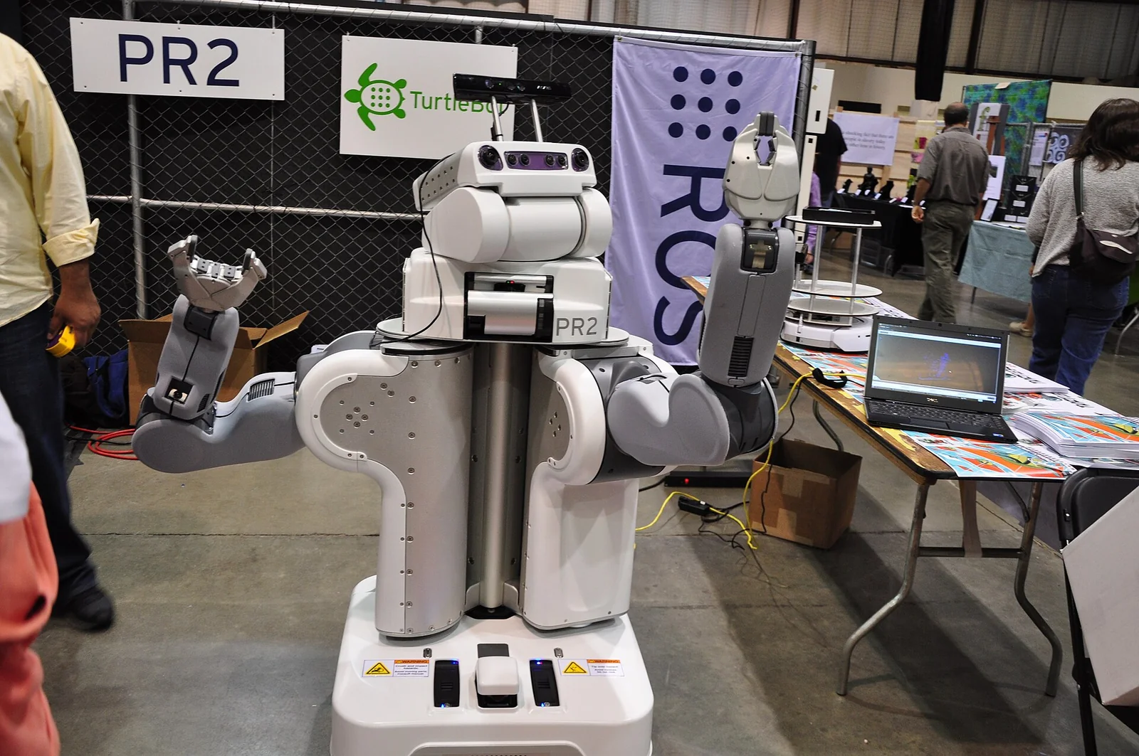 Il robot di ricerca PR2 di Willow Garage, con base mobile a ruote, due bracci e testa con sensori, esposto a un evento pubblico (Maker Faire 2011).